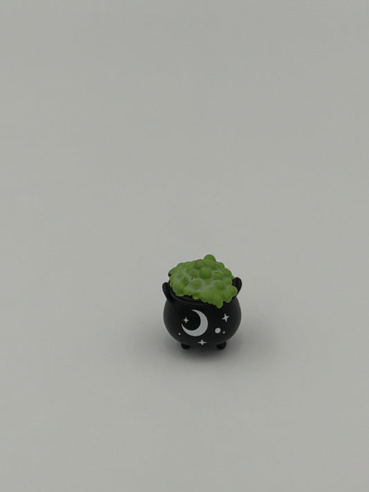Charm de bolsillo que brilla en la oscuridad con forma de caldero de bruja