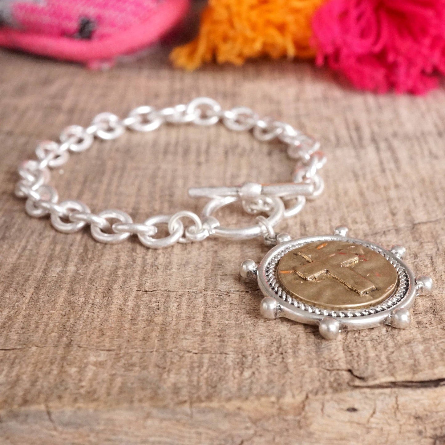 Pulsera de cadena con monedas cruzadas y cierre de palanca en tono plateado o dorado