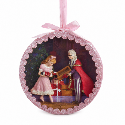 Nutcracker Suite Shadow Box Ornament, Drosselmeyer's Gift design: Drosselmeyer in his red cape handing Clara the nutcracker beside the tree