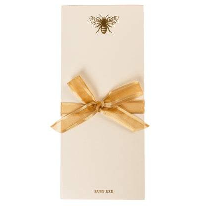La Petite Presse Bee Gilded Desktop Notepad, A cream notepad with a gold foil bee at the top and the words Busy Bee stamped in gold at the bottom, with a gold gilded edge.
