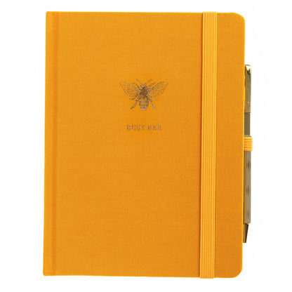 La Petite Presse Bee Fabric-Bound Journal with Pen, A marigold fabric journal with a gold foil bee and the words Busy Bee on the cover, paired with a gold twist pen.