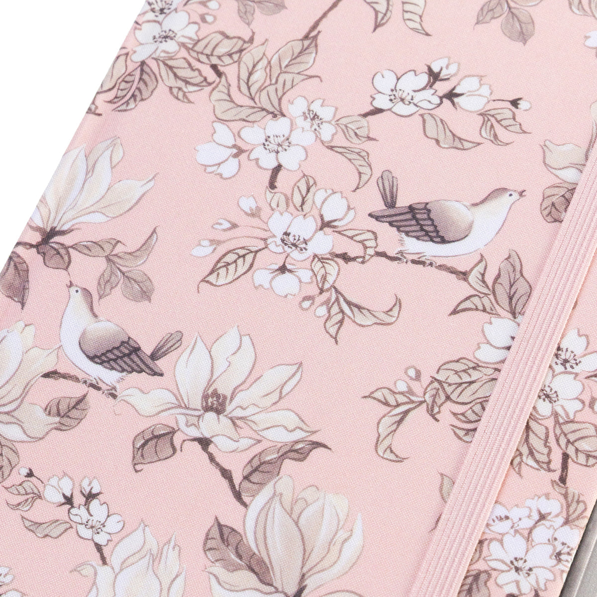 La Petite Presse Birds Fabric-Bound Journal with Pen, A blush pink fabric journal printed with songbirds and magnolia blossoms, closed with an elastic band and a silver pen tucked into a loop.