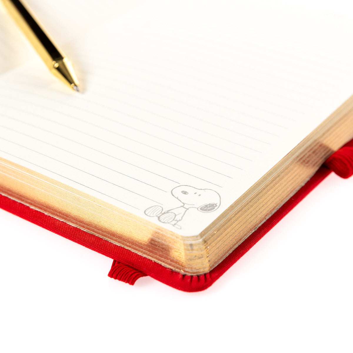 Peanuts Fabric-Bound Journal with Pen, A red fabric journal with a gold foil Snoopy illustration and the words happy notes, paired with a gold pen tucked into a loop along the spine.