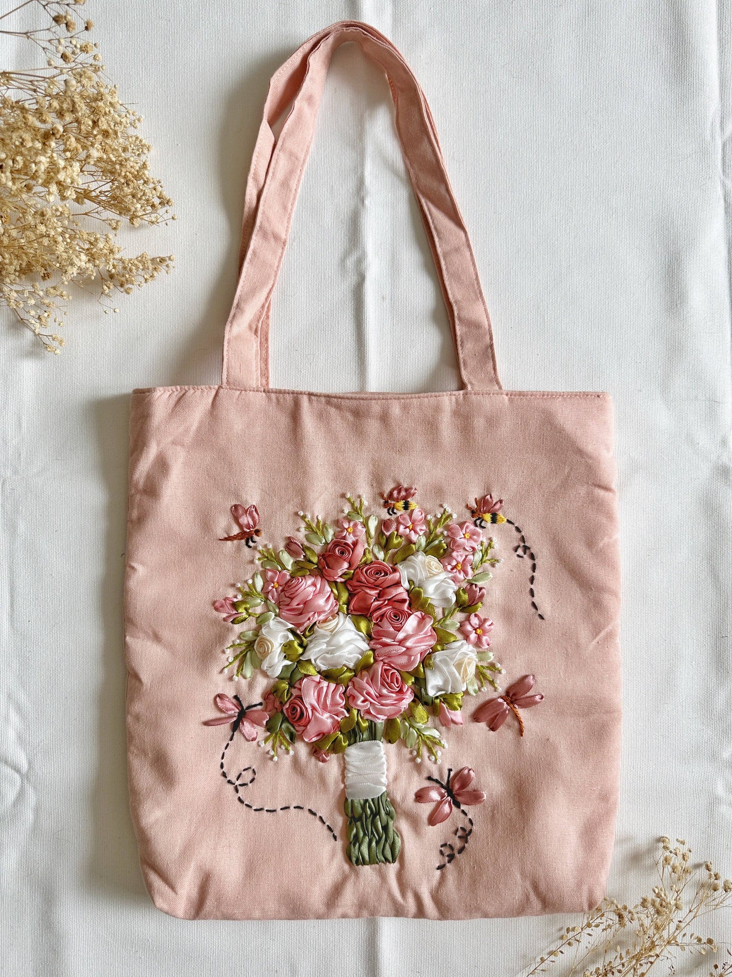 Bolsa de lino rosa con cinta bordada con ramo de flores