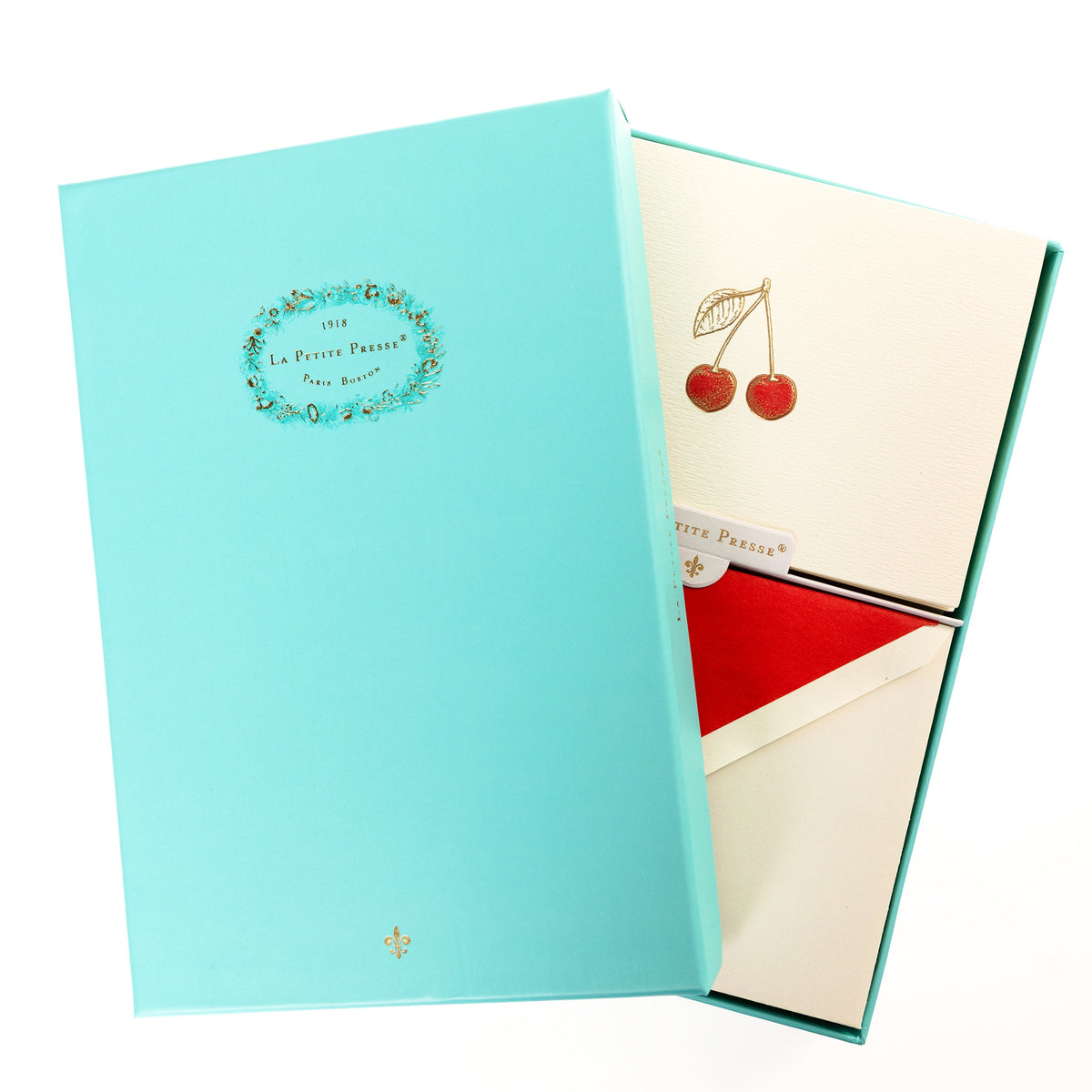 La Petite Presse Cherries Boxed Correspondence Notes, An ivory notecard with gold foil cherries filled in red glitter, paired with a cream envelope lined in bright red.