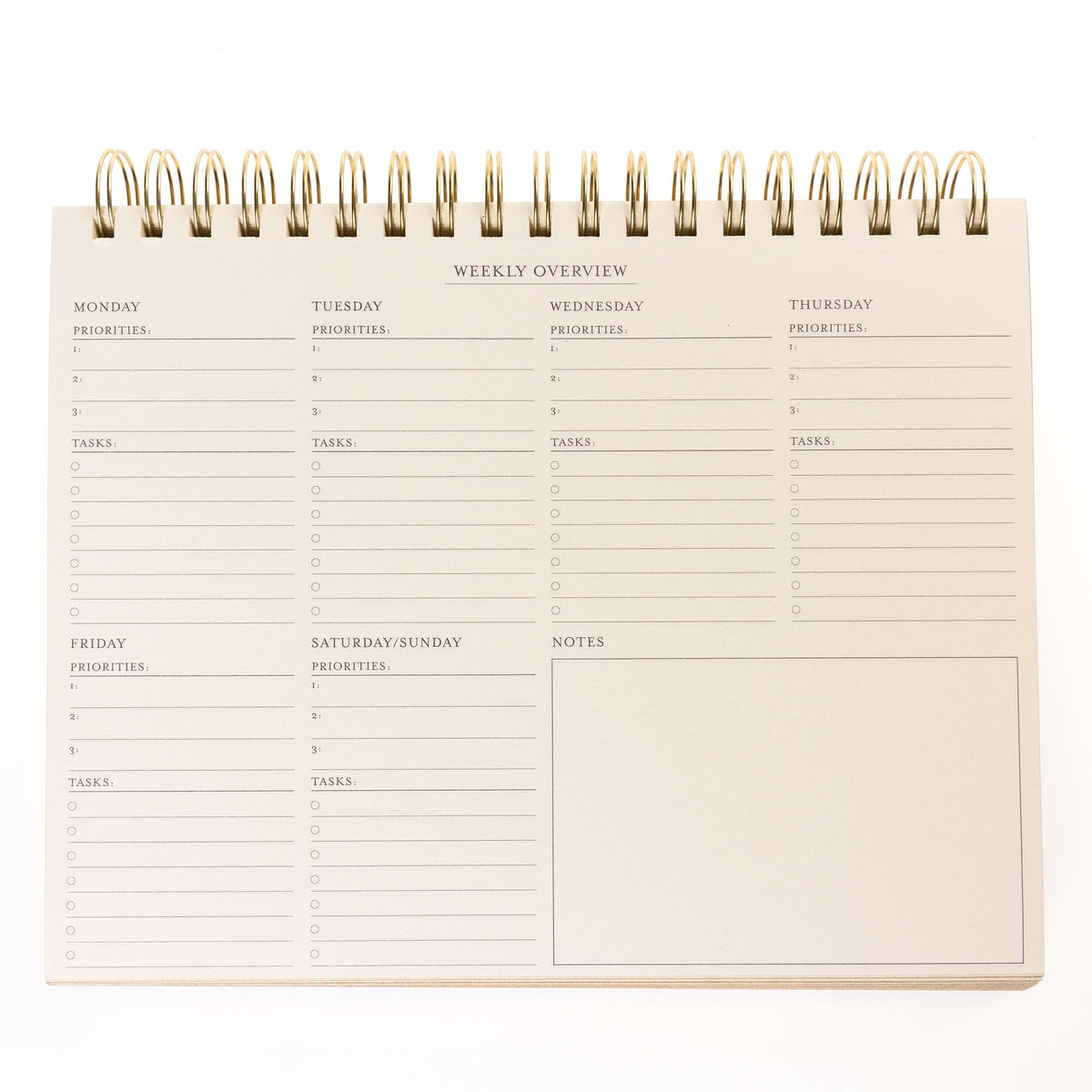 Cobalt Blue Fabric-Bound Weekly Desk Pad, A cobalt blue fabric desk pad reading days weeks in gold foil with a spiral top binding.