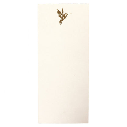 La Petite Presse Hummingbird Gilded Desktop Notepad, A cream notepad with a gold foil hummingbird at the top corner and a gold gilded edge, tied with a gold ribbon.