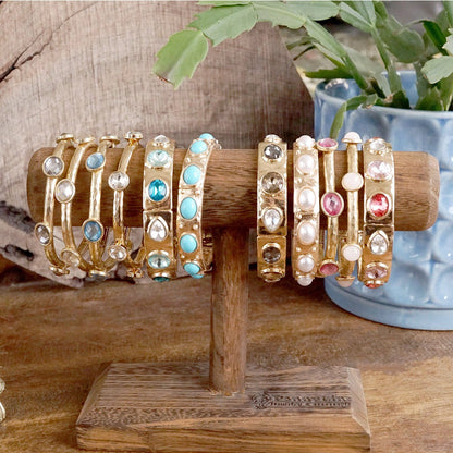 Brazalete de cristales transparentes brillantes en tono dorado o plateado.