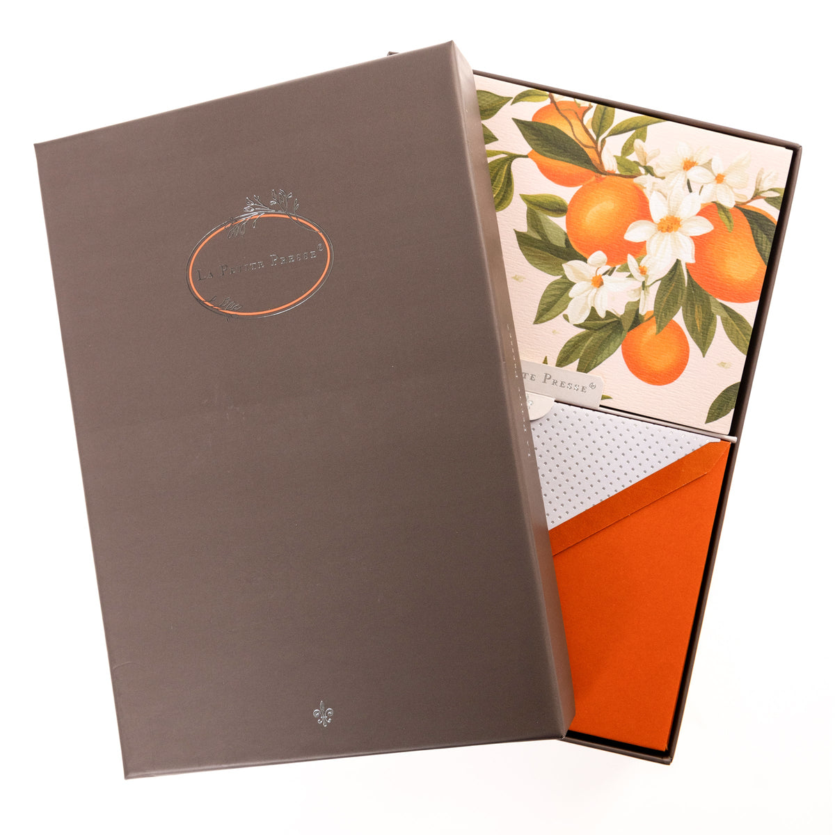 La Petite Presse L'Orange Boxed Correspondence Notes, A brown gift box open to a cream notecard printed with ripe oranges and white orange blossoms, paired with a bright orange envelope.