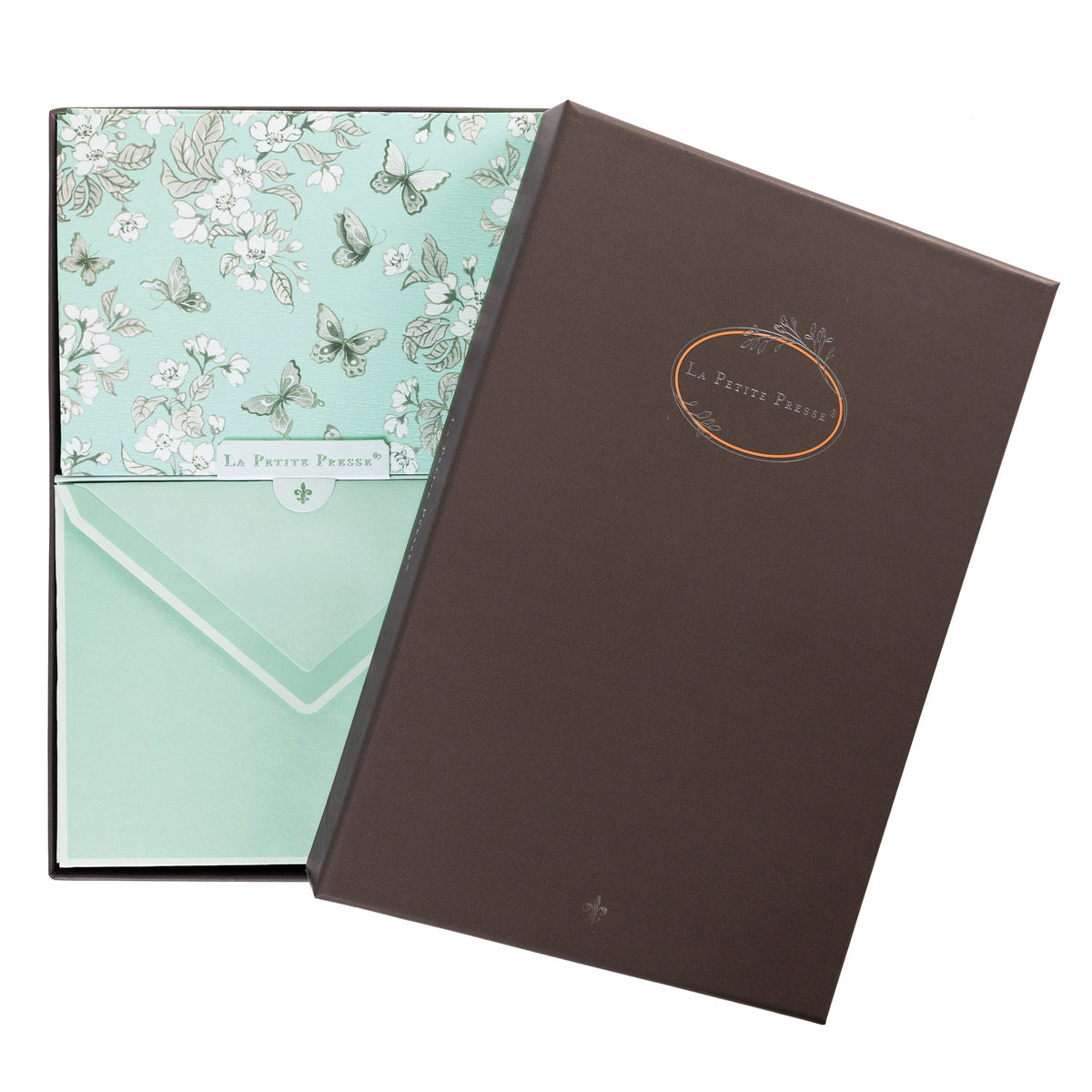 La Petite Presse Butterflies Boxed Correspondence Notes, A brown gift box open to reveal a seafoam green notecard with silver-foiled butterflies and cherry blossoms, paired with a matching mint envelope.