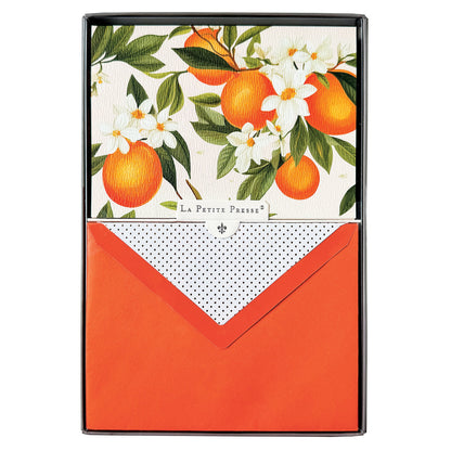 La Petite Presse L'Orange Boxed Correspondence Notes, A brown gift box open to a cream notecard printed with ripe oranges and white orange blossoms, paired with a bright orange envelope.