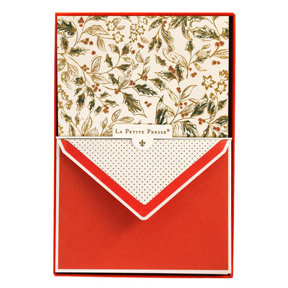 La Petite Noel Toile Holiday Boxed Correspondence Notes, A boxed Christmas correspondence card with a gold and green holly toile pattern on ivory cardstock, shown with its red envelope.