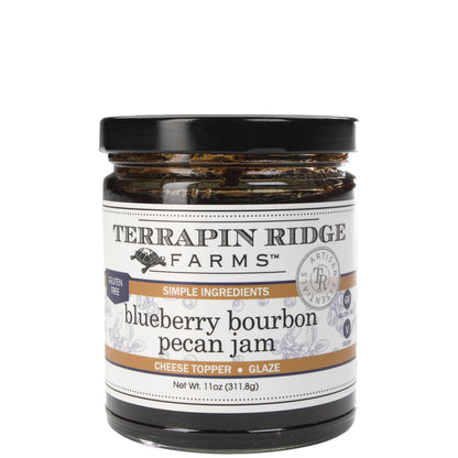 A glass jar of Terrapin Ridge Farms blueberry bourbon pecan jam with a black lid and a white label reading net wt. 11 oz.