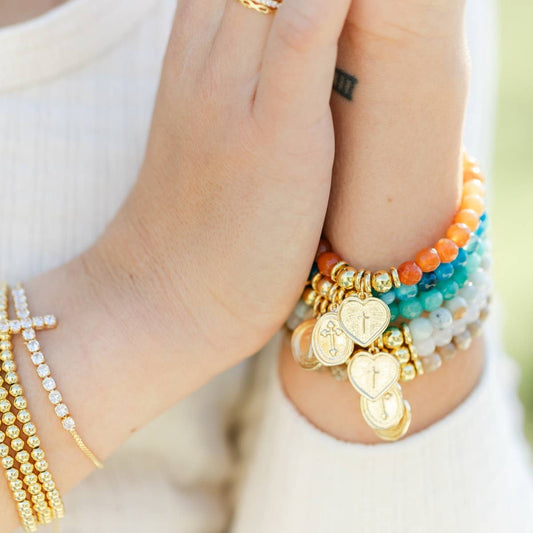 Pulsera elástica de piedras con dije de cruz de corazón