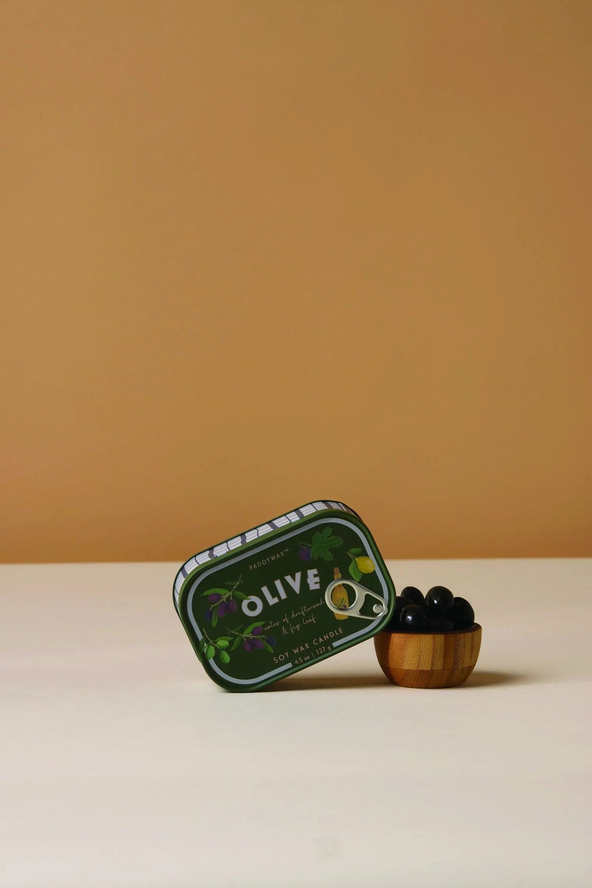 Bistro 4.5 oz Tin Candle, A pink tin candle illustrated with martini glasses, olives and a lemon, labeled Martini Soy Wax Candle.
