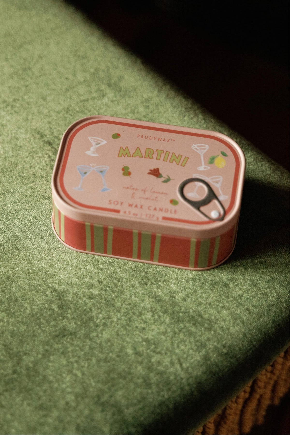 Bistro 4.5 oz Tin Candle, A pink tin candle illustrated with martini glasses, olives and a lemon, labeled Martini Soy Wax Candle.