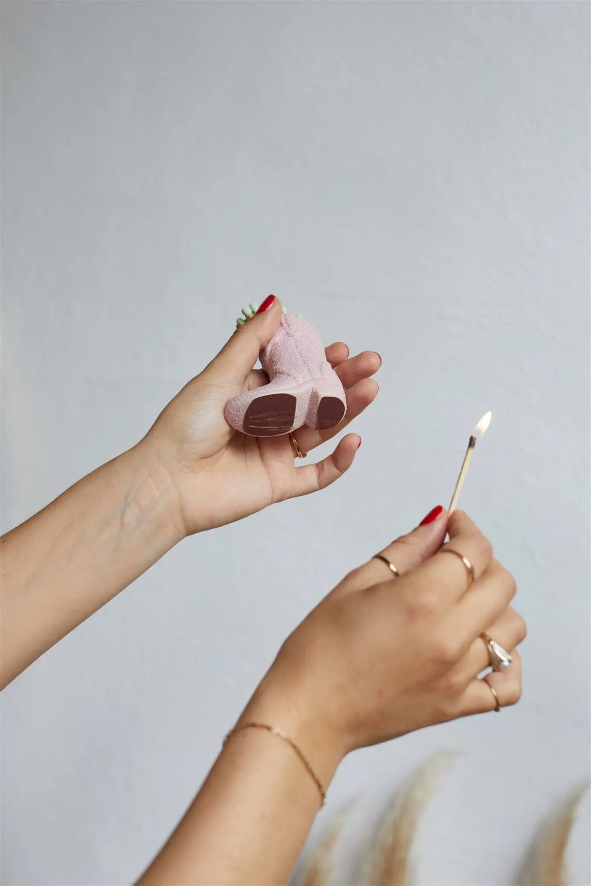 Cowboy Boot Match Holder, A matte white ceramic cowboy boot holds a bundle of pink-tipped matches beside its kraft packaging box.