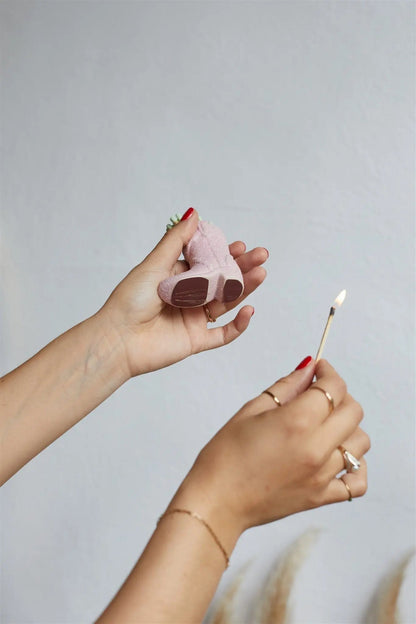 Cowboy Boot Match Holder, A matte white ceramic cowboy boot holds a bundle of pink-tipped matches beside its kraft packaging box.