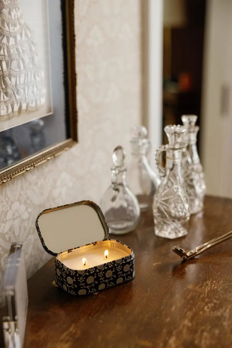Chérie 4.5 oz Tin Candle, A black metal tin printed with a cream floral pattern, labeled Black Fig and Olive Soy Wax Candle.