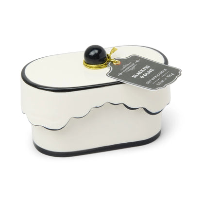 Chérie 5.5 oz Ceramic Candle, A white ceramic lidded candle box with a black scalloped rim and a round knob, tagged Black Fig and Olive.