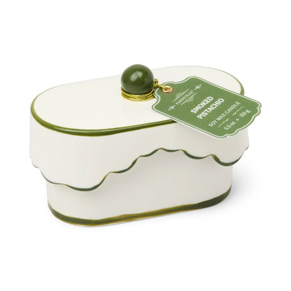 Chérie 5.5 oz Ceramic Candle, A white ceramic lidded candle box with a black scalloped rim and a round knob, tagged Black Fig and Olive.