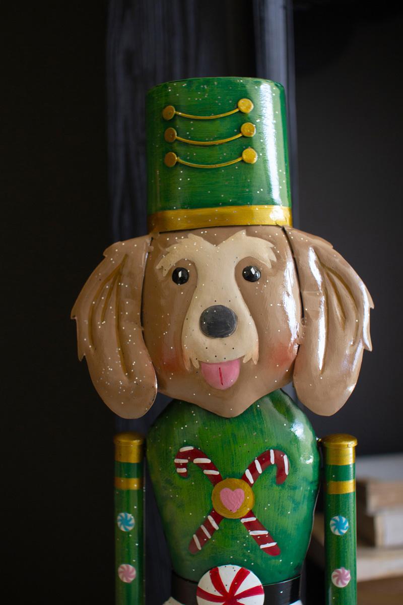 Painted Metal Dog Nutcracker, Golden Retriever design: a close view of the golden retriever head with long cream ears under a green shako hat, above a green tunic with a candy cane.