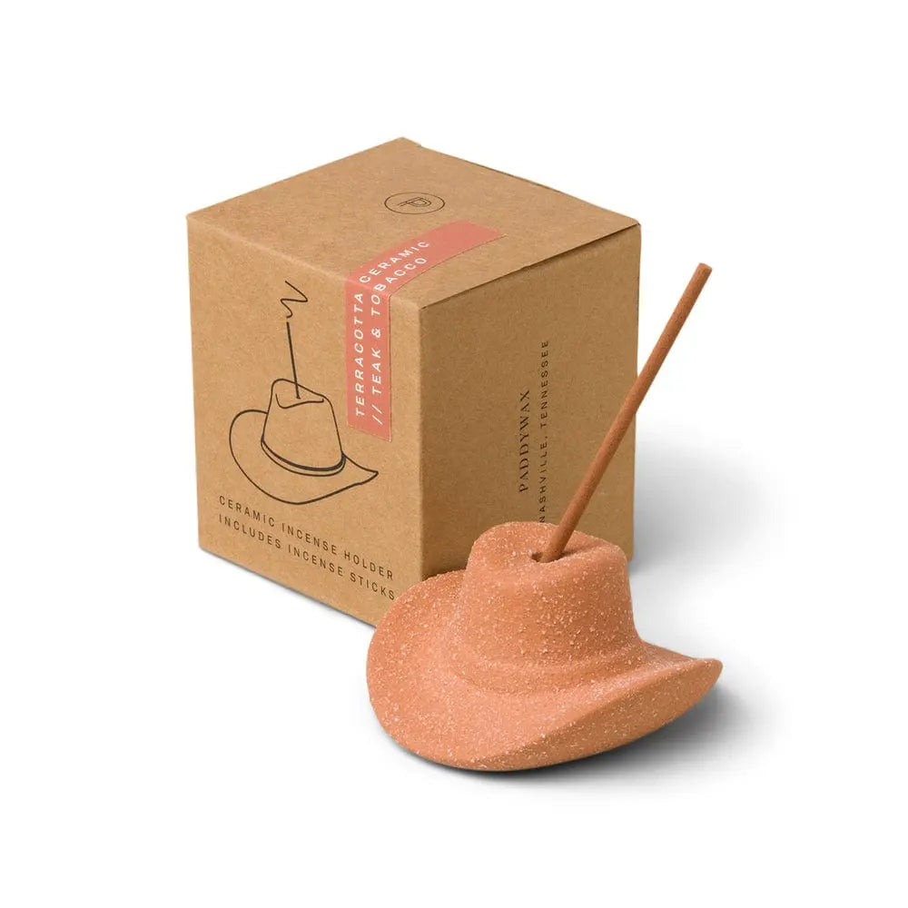 Teak & Tobacco Cowboy Hat Incense Holder, A terracotta ceramic cowboy hat incense holder with one incense stick standing in the crown, next to its kraft packaging box.
