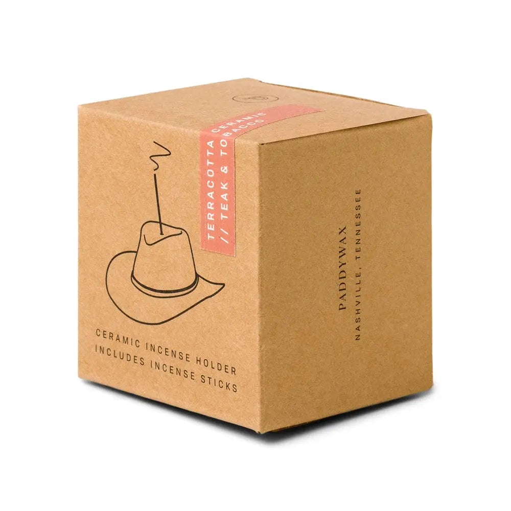 Teak & Tobacco Cowboy Hat Incense Holder, A terracotta ceramic cowboy hat incense holder with one incense stick standing in the crown, next to its kraft packaging box.