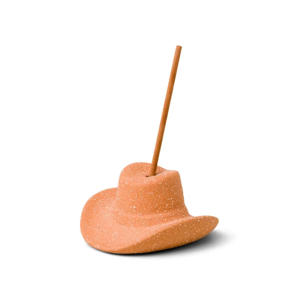 Teak & Tobacco Cowboy Hat Incense Holder, A terracotta ceramic cowboy hat incense holder with one incense stick standing in the crown, next to its kraft packaging box.