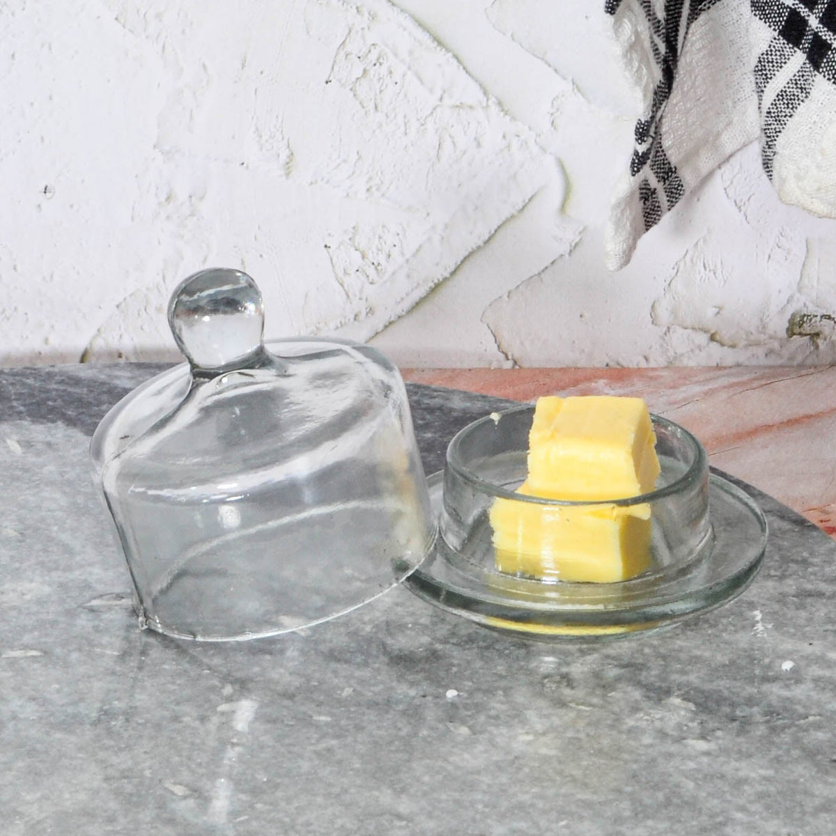 Lucent Glass Butter Dish, A clear glass butter dish with its domed lid removed and set beside the round base, on a white background.