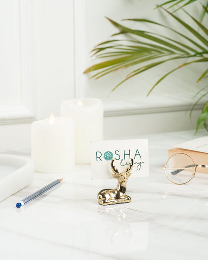 Blitzen Reindeer Placecard Holder, Gold, A small brass reindeer figure in a gold finish, lying down with its antlers raised.