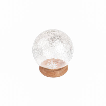 Adonis Snow Globe, A clear, crackled glass snow globe patterned with white snowflakes, set on a round natural wood base.