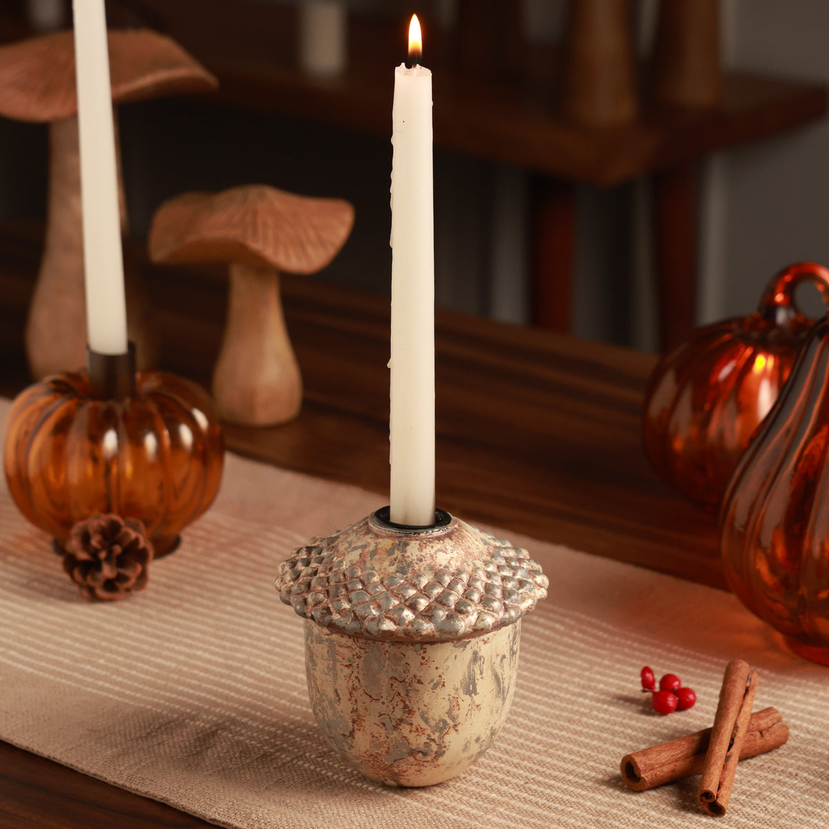 Juno Russet Glass Acorn Candle Holder, An acorn shaped glass candle holder in a copper gold finish with a textured beaded cap and a taper opening on top, shown alone.