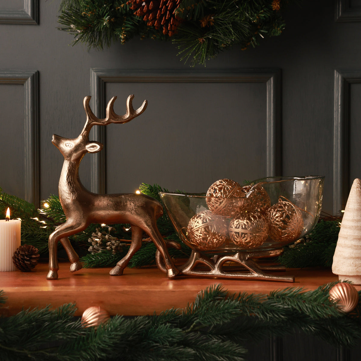 Nordelle Reindeer Sleigh, A champagne gold metal reindeer pulling a clear glass sleigh-shaped dish on champagne gold metal runners.