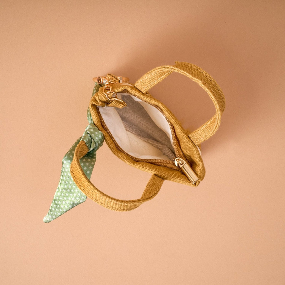 Tiny Tote Bag Charm, A miniature tan and cream canvas style tote bag charm with an orange floral bouquet print and gold tone hardware, in the Honey Blossom design.