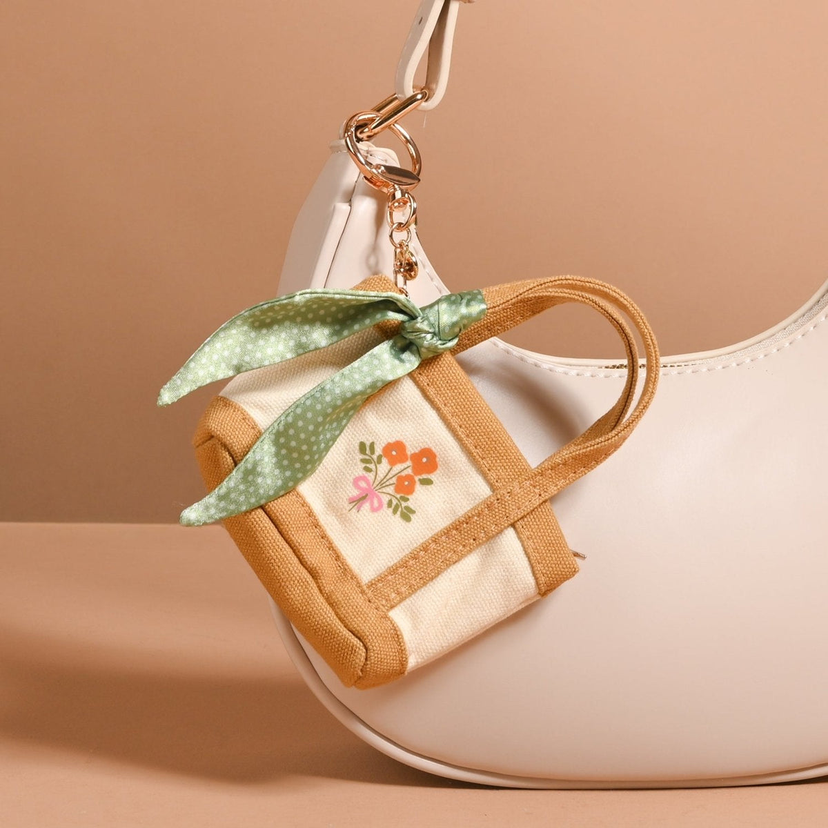 Tiny Tote Bag Charm, A miniature tan and cream canvas style tote bag charm with an orange floral bouquet print and gold tone hardware, in the Honey Blossom design.