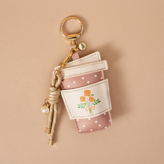 Vegan Leather Bag Charm, A dog shaped bag charm in cognac vegan leather with floppy ears, a small collar tag, and a burgundy cord tassel with a pearl bead.