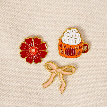 Enamel Pin Pack, A boxed set of three gold enamel pins in the Latte Love design, a coffee cup, a teddy bear, and a pink bow.