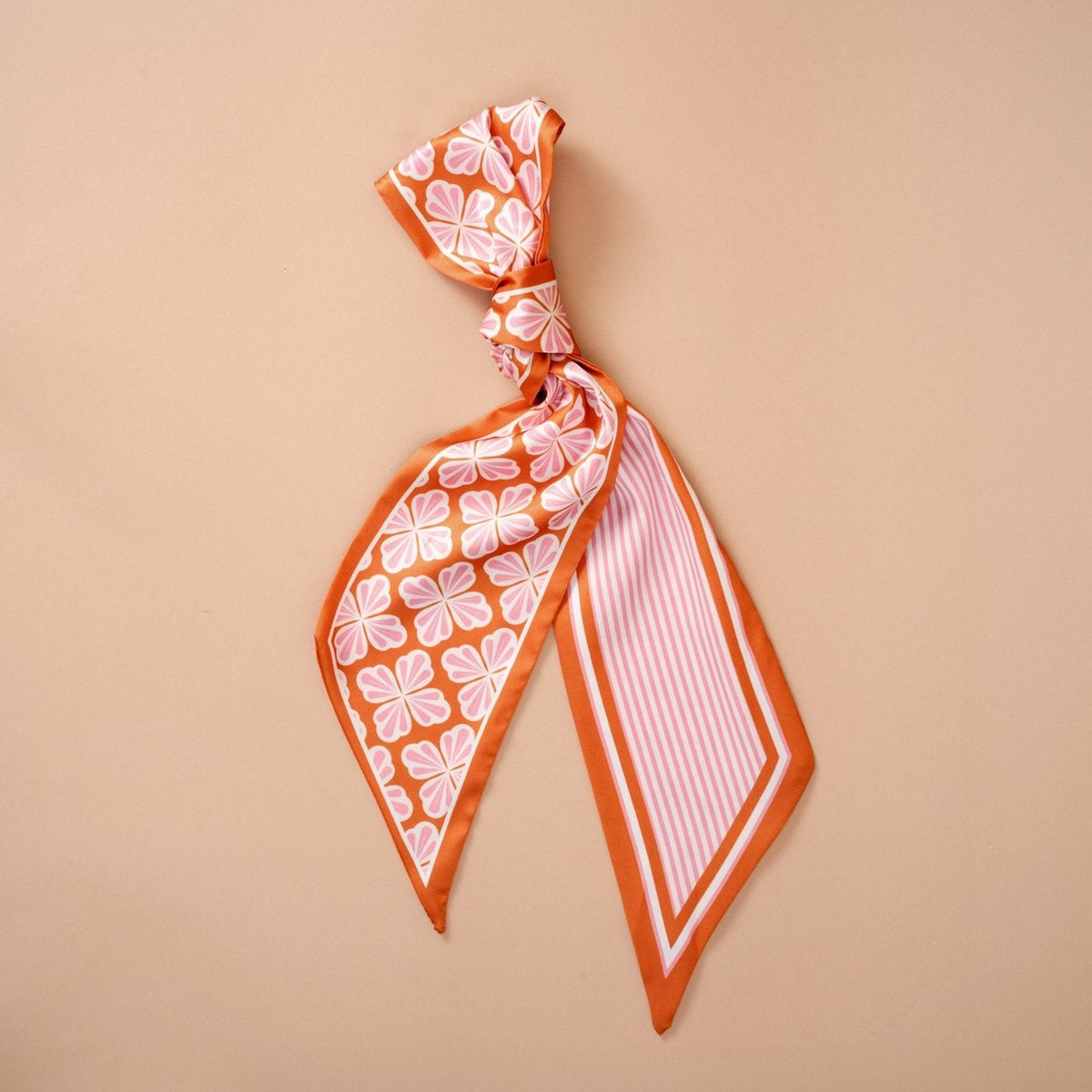 Twirl & Tie Scarf Accessory, A red and white gingham satin scarf tied in a knot, showing a red polka dot pattern on the reverse side of the tails.