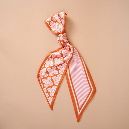 Twirl & Tie Scarf Accessory, A red and white gingham satin scarf tied in a knot, showing a red polka dot pattern on the reverse side of the tails.