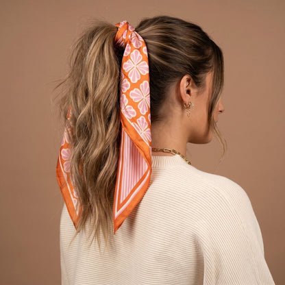 Twirl & Tie Scarf Accessory, A red and white gingham satin scarf tied in a knot, showing a red polka dot pattern on the reverse side of the tails.