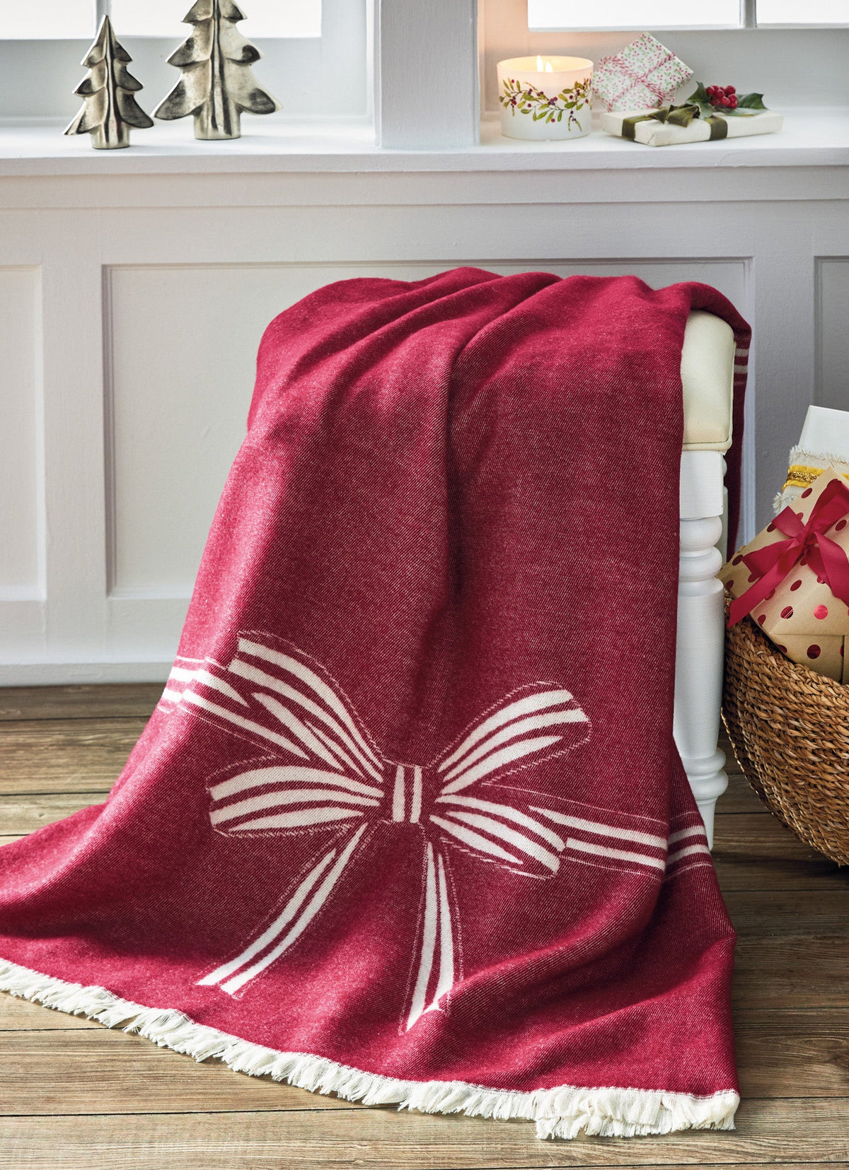Bow Reversible Throw, A folded red and cream reversible throw blanket with a woven bow design and fringed edges.