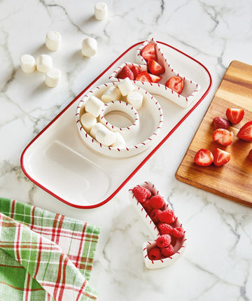 Joy Platter and Dish Set of 4, A rectangular white platter with a red rim holding three white letter dishes that spell JOY, each trimmed in red stitch marks.