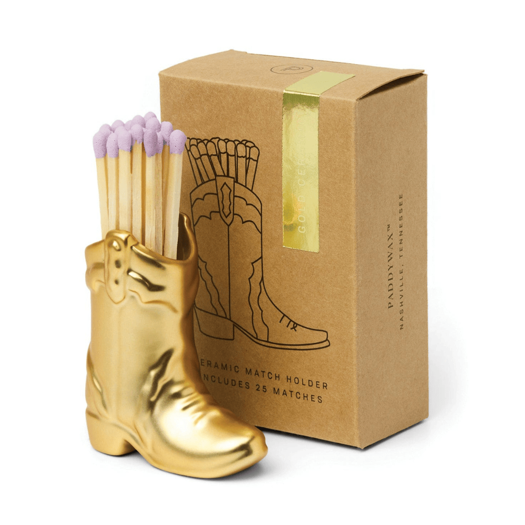Cowboy Boot Match Holder, A matte white ceramic cowboy boot holds a bundle of pink-tipped matches beside its kraft packaging box.