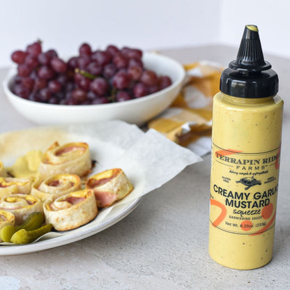 Creamy Garlic Mustard Garnishing Squeeze, 8.25 oz, shown in a styled setting