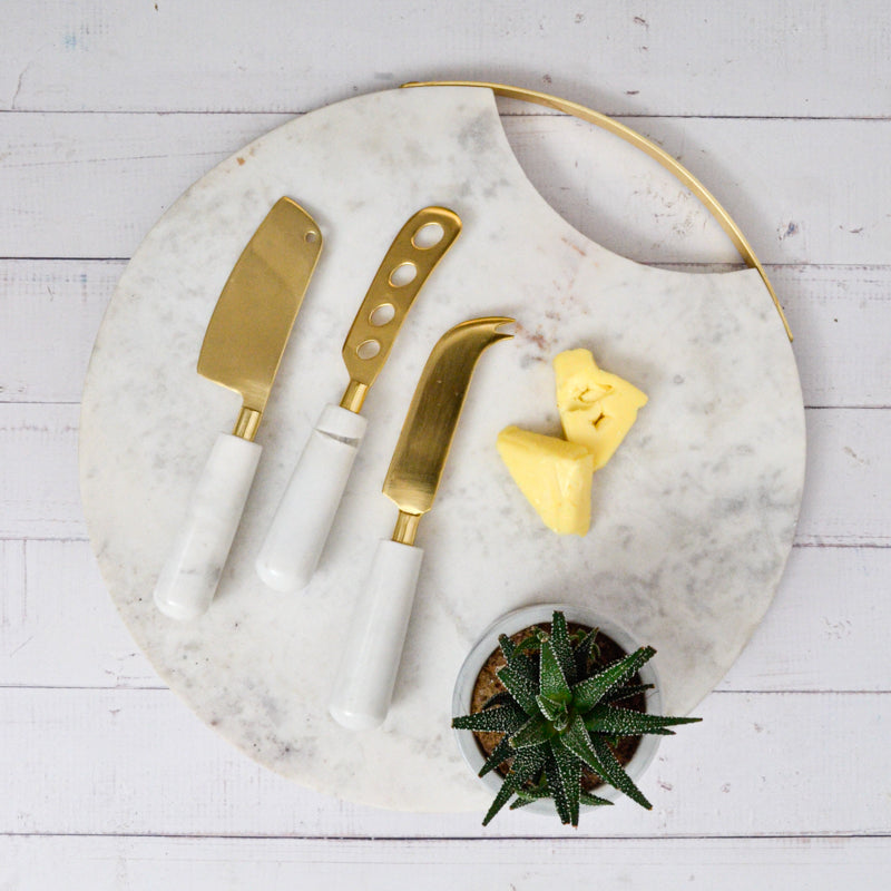 Calandiva Cheese Knife Set with White Stone Handles, Three cheese knives with gold-finish blades and white stone handles, laid side by side on a white background.