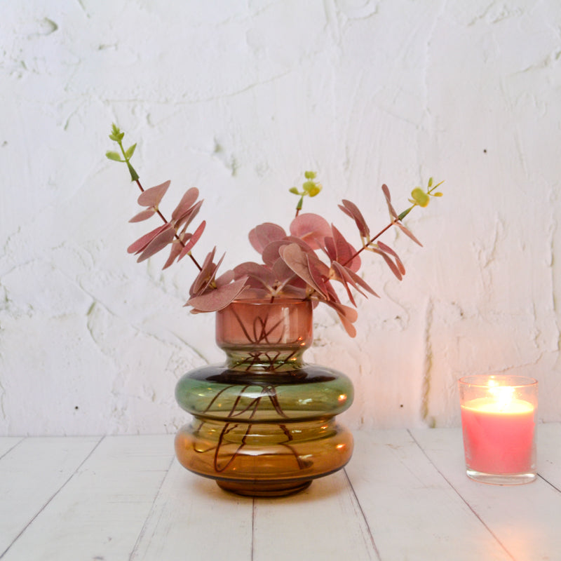 Scabiosa Tiered Glass Vase, A tiered glass vase with a pink neck, a rounded green middle band, and a wider amber base, on a white background.