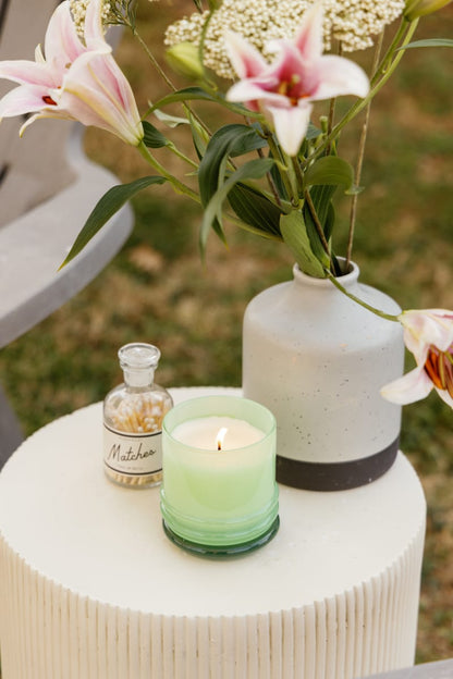 Stack 7 oz Candle, A blush pink glass candle with a maroon stacking lid, labeled Saffron Rose Soy Wax Candle, 7 oz.