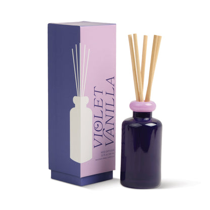 Stack 3.2 oz Diffuser, A maroon glass reed diffuser bottle with pink topped reeds standing next to its packaging box labeled Saffron Rose.