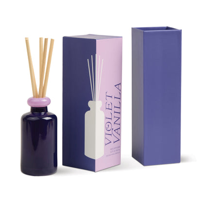 Stack 3.2 oz Diffuser, A maroon glass reed diffuser bottle with pink topped reeds standing next to its packaging box labeled Saffron Rose.